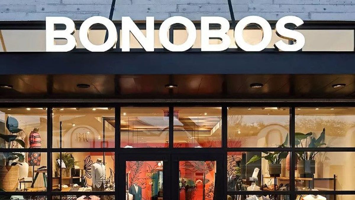 A the interior of a store glows through the front windows, with a sign reading "Bonobos" in white capital letters above.