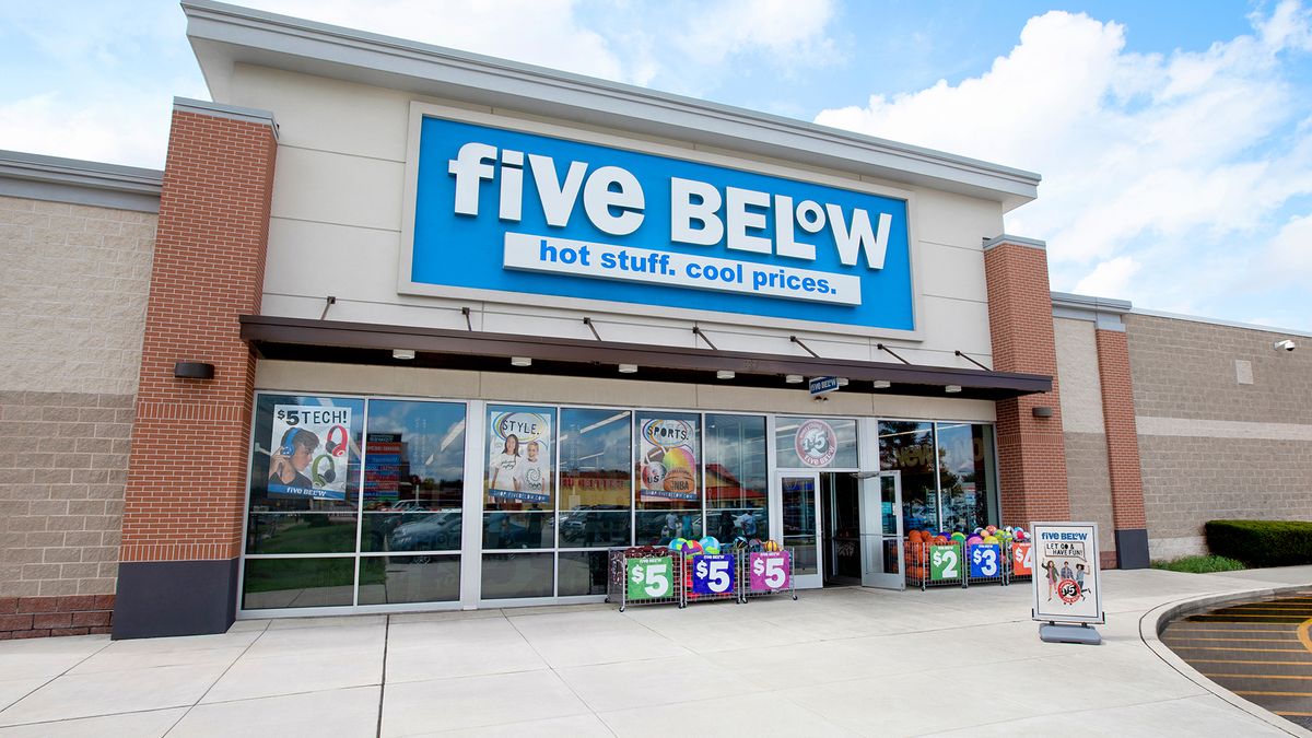 The exterior of a Five Below store during the daytime with a blue sky