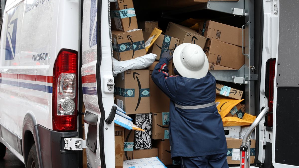 A U.S. Postal Service worker unpacks packages from a truck on December 02, 2019 in San Francisco, California.