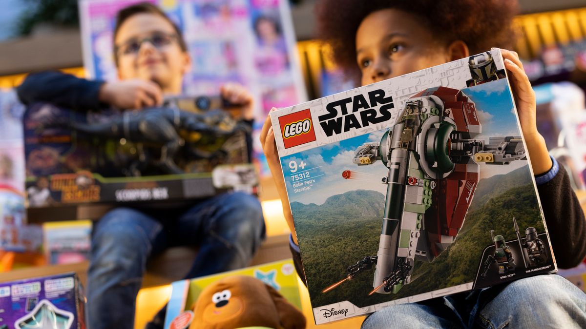 A child holds a toy box for the 'Star Wars Boba Fett Starship.'