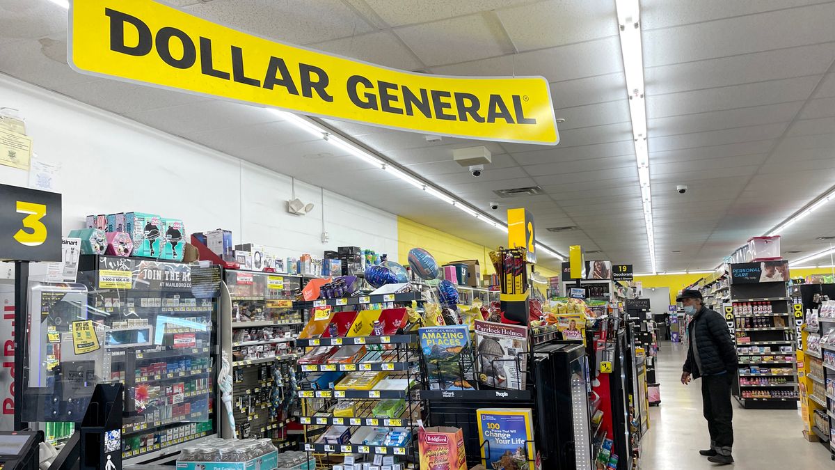 Interior of a store with a yellow "Dollar General" sign hanging from the ceiling.