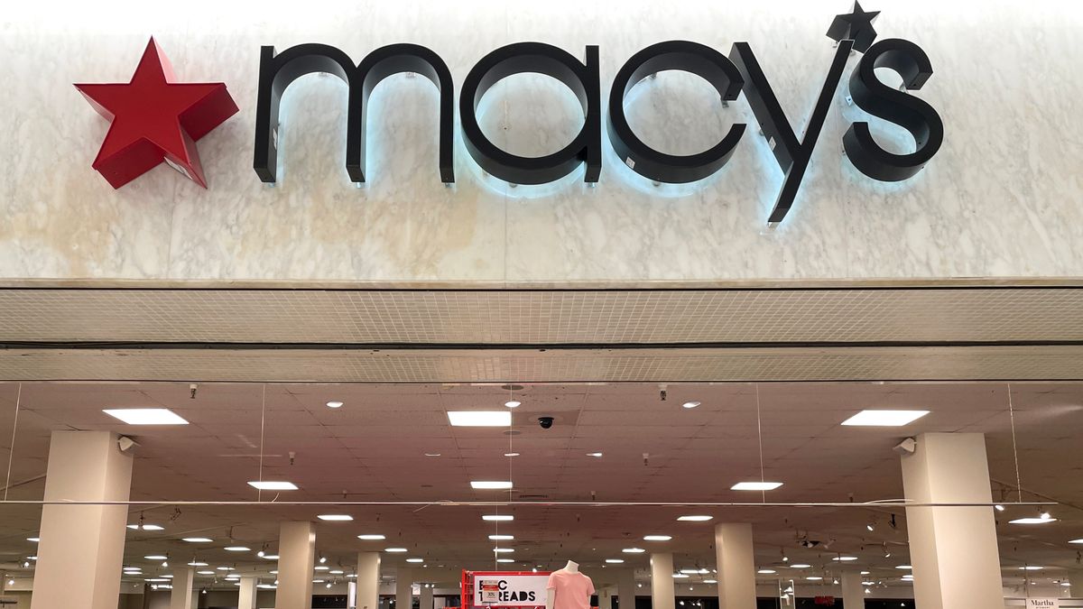 The Macy's logo is seen above a display of clothing for sale