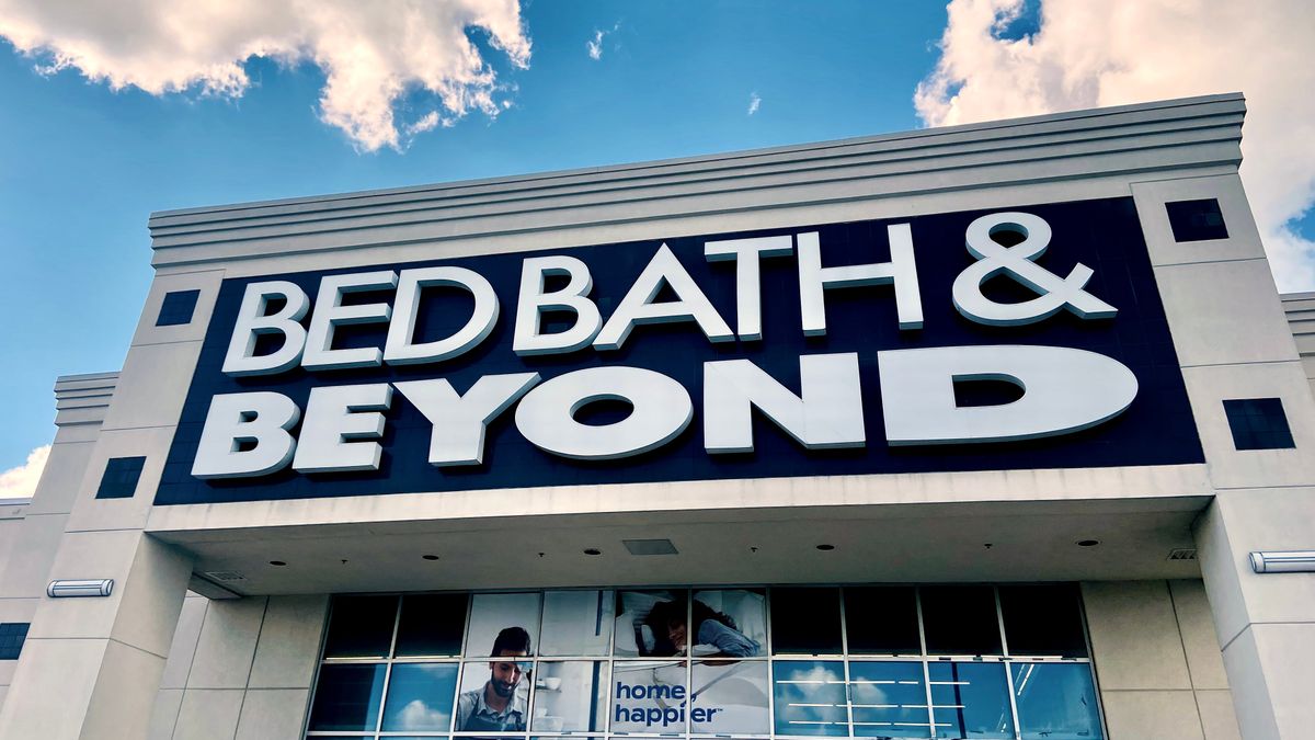 Puffy clouds in a blue sky frame a storefront that says "Bed Bath & Beyond" in large dark letters.