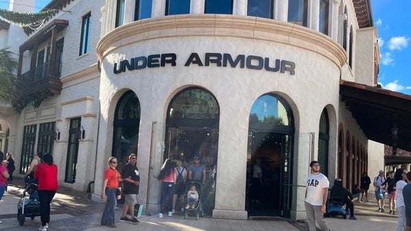 Shoppers walking by an Under Armour store.
