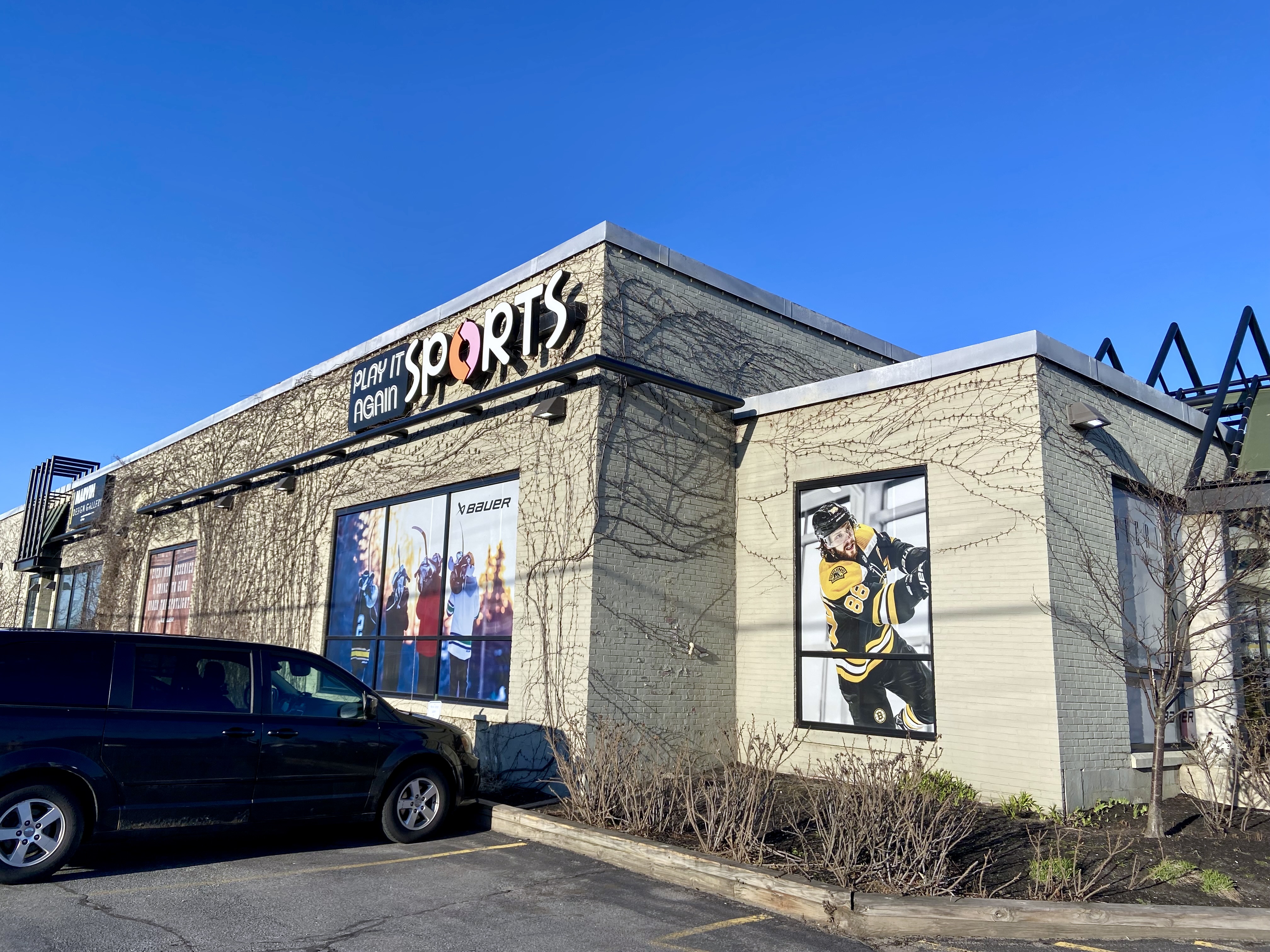 A store seen at an angle, with "Sports" on one corner, and a photo of a hockey player prominent on the right.