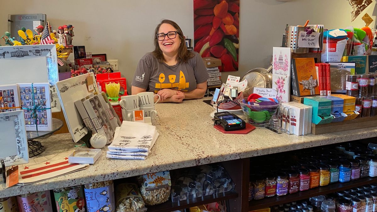 Leah Daniels is behind a counter at her Hill's Kitchen store.