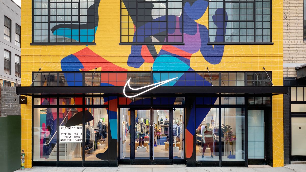 A yellow Nike storefront with a mural of runners on the outside.