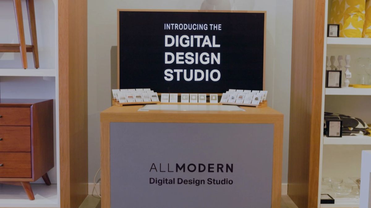 A light wood kiosk with a computer screen saying Digital Design Studio